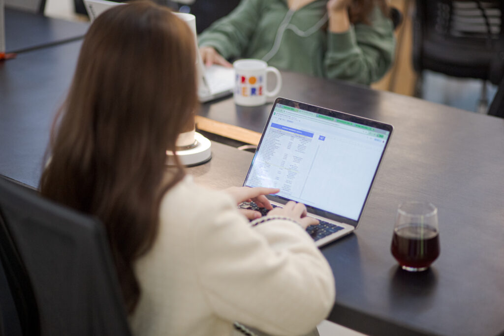 Woman working on a laptop inside From Here Cebu’s coworking space.