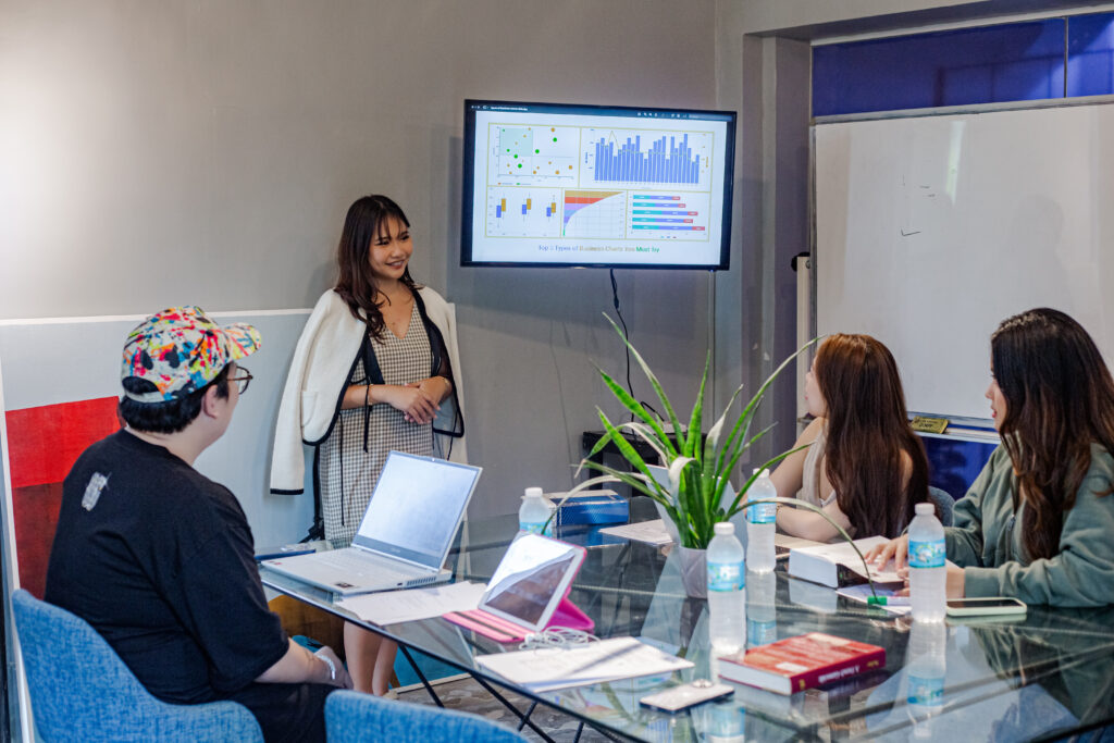 Team in a meeting room at From Here Cebu watching a presentation on a screen.